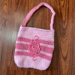 Handmade pink and light pink striped crochet shoulder bag with flower appliqués